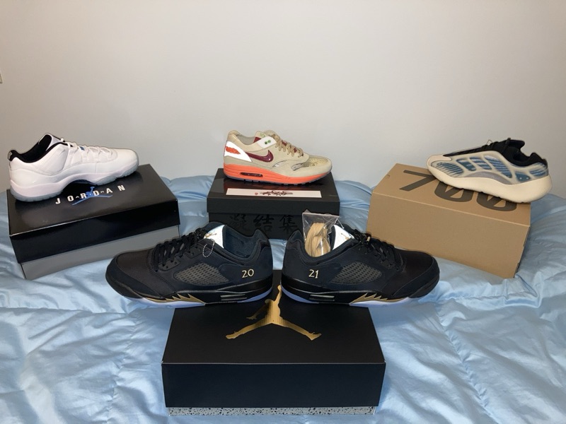 Sneaker inventory laid out on the bed