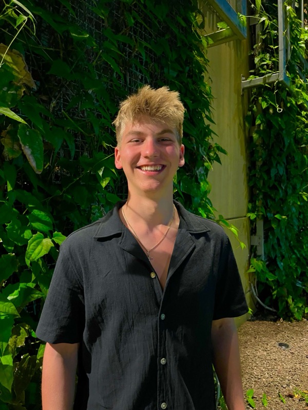 Smiling in front of a wall of vines